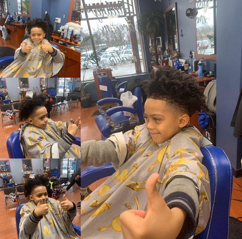 A collage of four images of a child giving the thumbs up approval of his haircut.