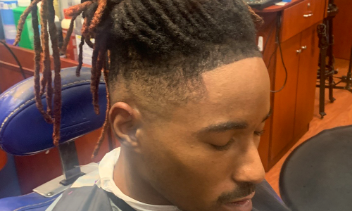 A Client sitting still in a barber chair after his haircut.